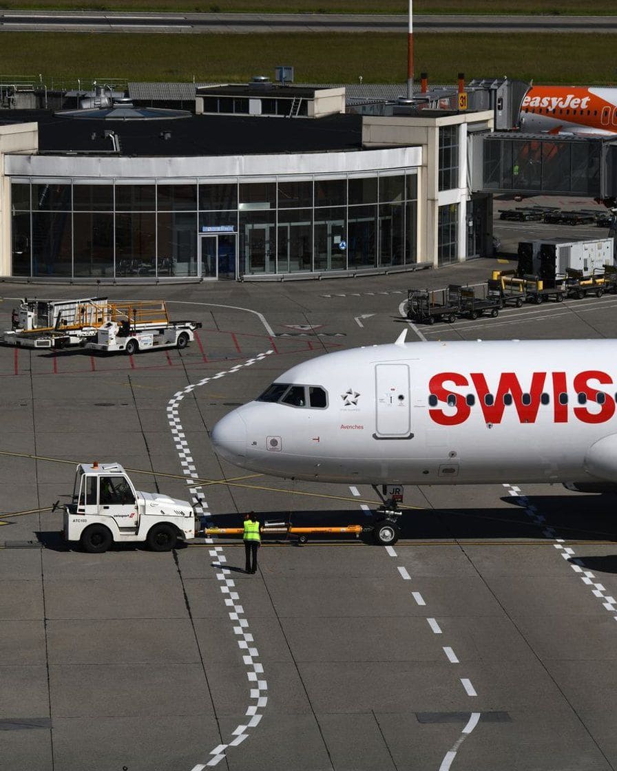 Parking couvert de l'aéroport de Genève, rangées de voitures sous les panneaux de signalisation des niveaux