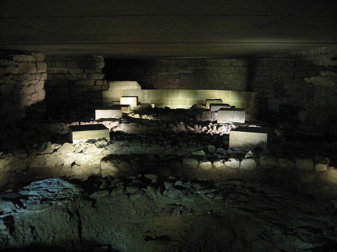 Vestiges éclairés du site archéologique sous la cathédrale Saint-Pierre de Genève, murs anciens et sols successifs
