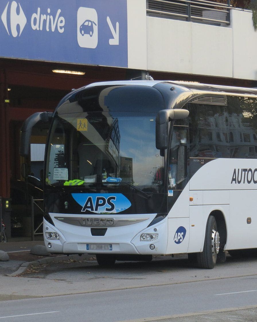 Autocar sur l'autoroute entre Genève et Annecy, avec les montagnes de Haute-Savoie à l'horizon