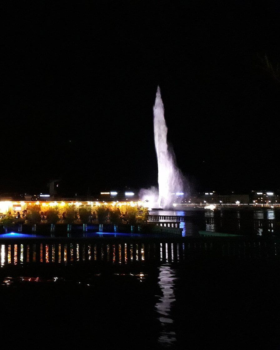 Tables de la buvette des Bains des Pâquis sur la jetée du lac Léman à Genève, face à la rade et au Jet d'eau, un soir d'hiver