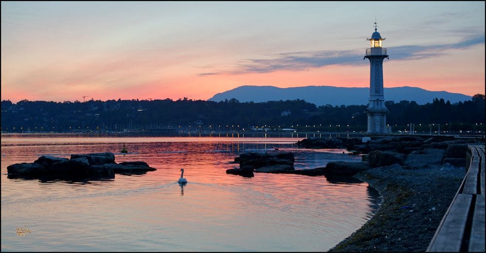 Les Bains des Pâquis au crépuscule, avec le phare de la jetée et le lac encore clair