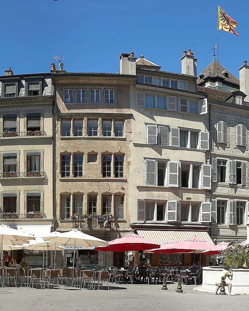La place du Bourg-de-Four, au cœur de la Vieille Ville de Genève, avec sa fontaine et ses terrasses au pied de façades anciennes