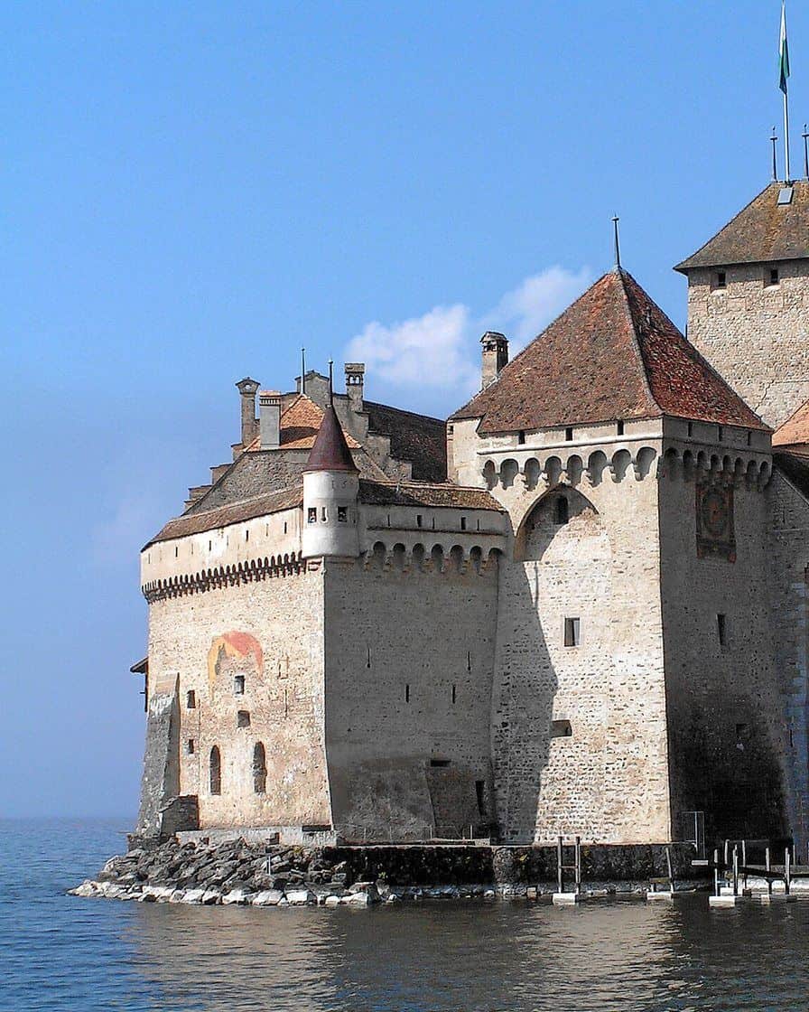 Le château de Chillon posé sur un rocher au bord du lac Léman, près de Montreux, avec les montagnes en arrière-fond