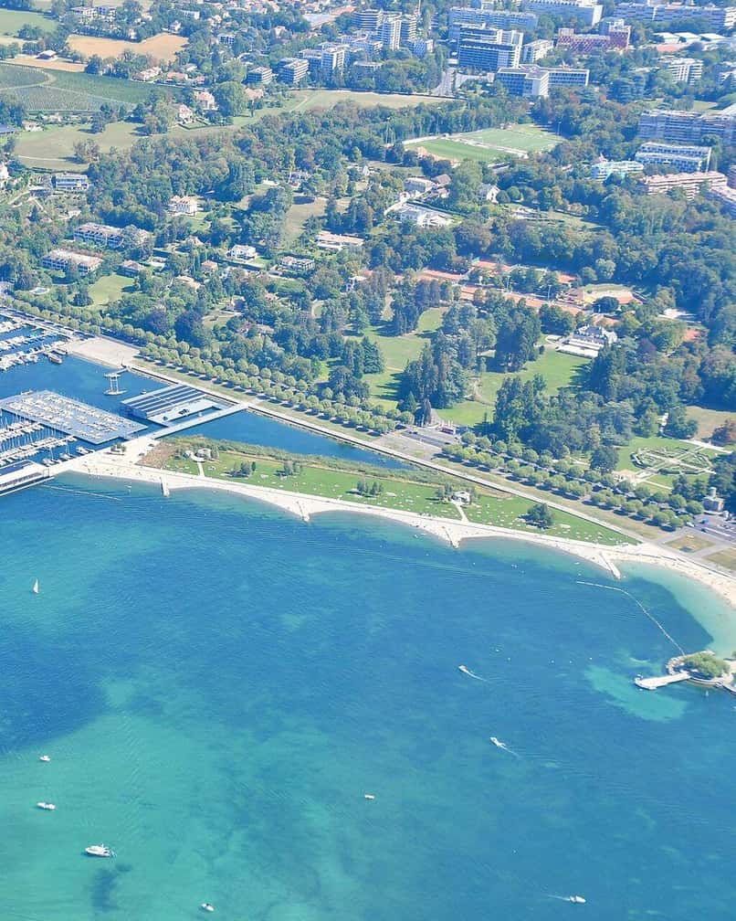 La plage publique des Eaux-Vives à Genève, ses gradins et son accès au lac Léman, avec le Jet d'eau tout proche