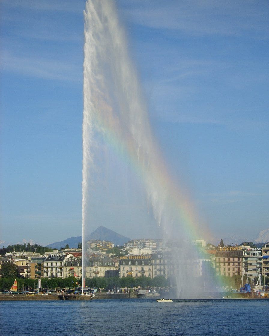 Le Jet d'eau de Genève projeté à 140 mètres au-dessus de la rade, panache blanc devant le ciel bleu et les montagnes