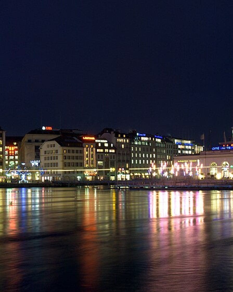 Le marché de Noël Noël au Quai sur le quai du Mont-Blanc à Genève, chalets illuminés au bord du lac à la tombée de la nuit