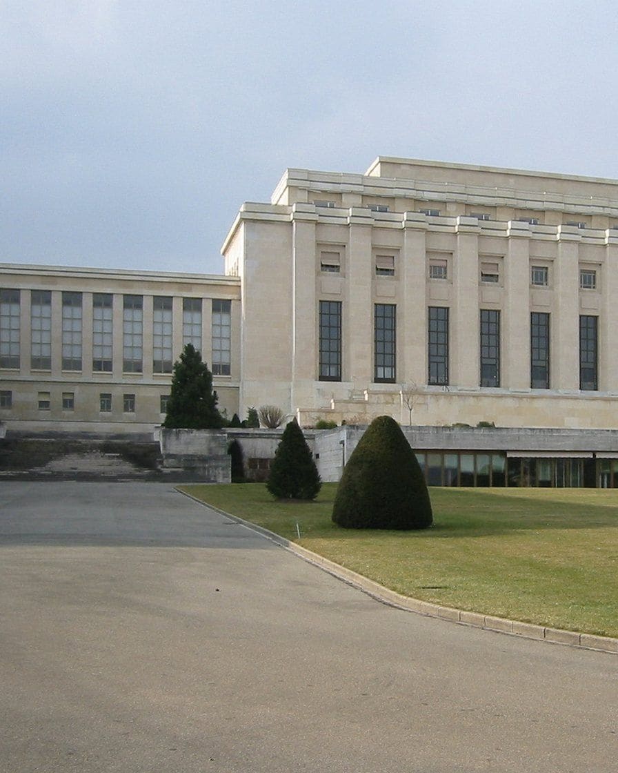 Le Palais des Nations à Genève et l'allée des drapeaux des États membres devant le siège européen de l'ONU