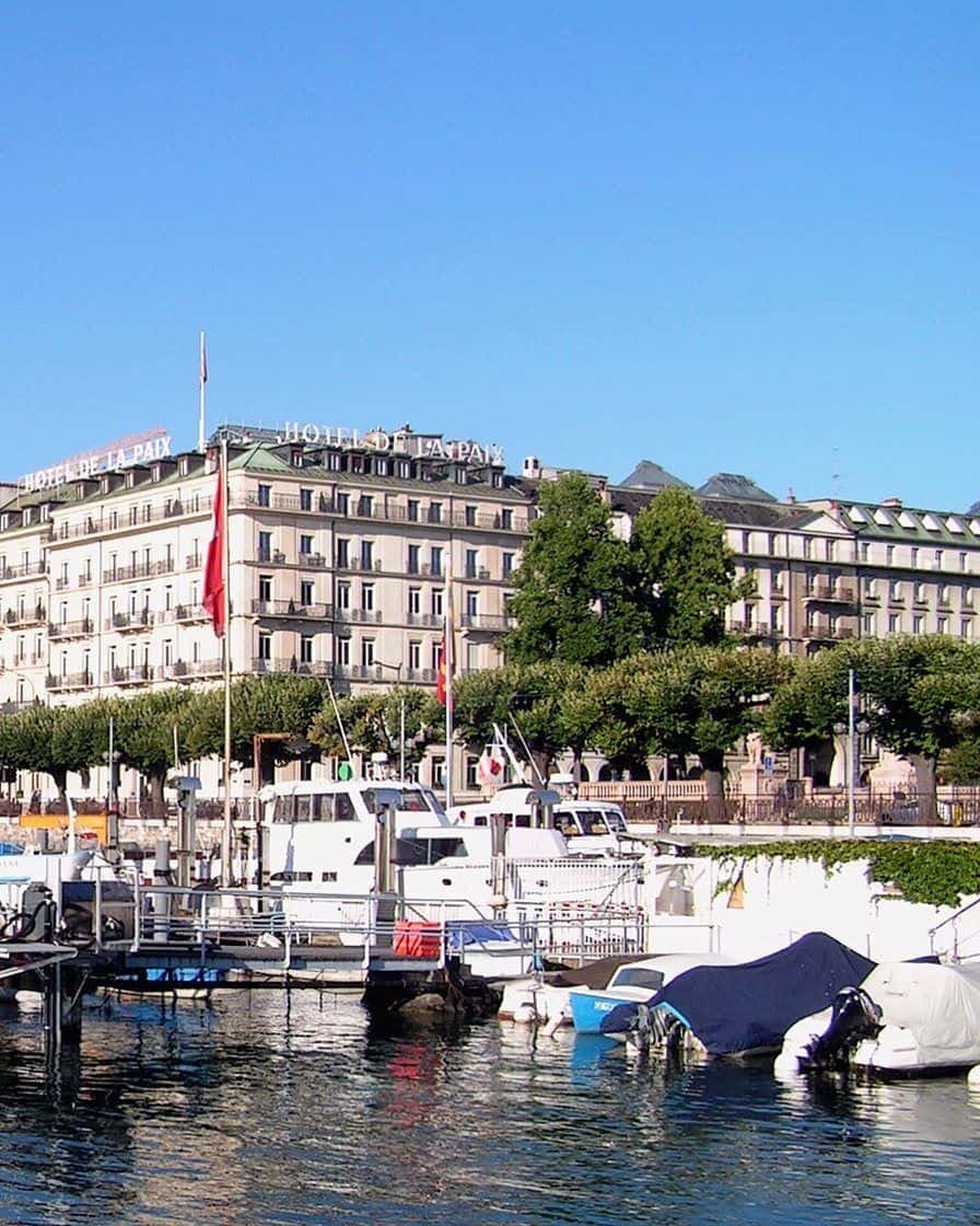 Le quai du Mont-Blanc à Genève illuminé pour les fêtes de fin d'année, avec les chalets du marché et la rade la nuit