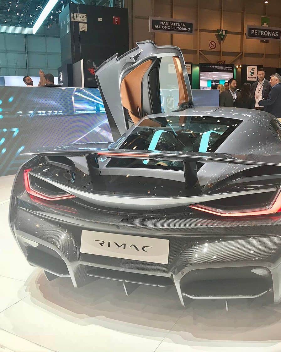 Une halle du Salon international de l'automobile de Genève à Palexpo, avec des voitures exposées sur des stands éclairés