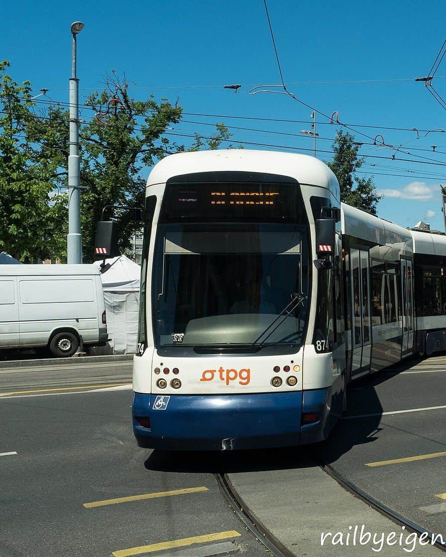 Un tram tpg traverse le quartier de Plainpalais à Genève, avec des voyageurs à l'arrêt