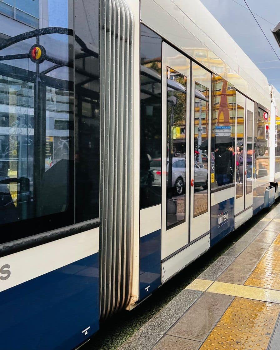 Tram des Transports publics genevois à l'arrêt Rive, sur la rive gauche de Genève, avec des voyageurs qui montent